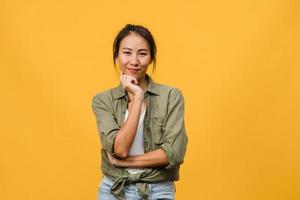 Portrait of young Asia lady with positive expression, arms crossed, smile broadly, dressed in casual clothing and looking at camera over yellow background. Happy adorable glad woman rejoices success. photo