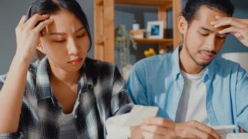 Stress asia couple man and woman use calculator for calculate family budget, debts, monthly expenses during financial economic crisis at home. marriage money trouble, Family budget planning concept. photo