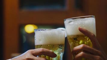 Group of happy tourist young Asia friends drinking alcohol or craft beer and having hangout party in night club at The Khao San Road. Traveler backpacker Asia people travel in Bangkok, Thailand. photo