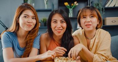 Attractive Asian lovely lady girl group positive glad cheerful with casual have fun and enjoy watch online movie entertainment on couch in living room at home. Lifestyle activity quarantine concept. photo