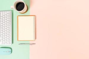 Creative flat lay photo of workspace desk. Top view office desk with keyboard, mouse and open mockup black notebook on pastel green pink color background. Top view mock up with copy space photography.