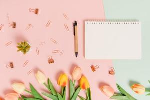 Creative flat lay of travel vacation spring or summer tropical fashion. Top view beach accessories open mockup black notebook for text on pastel background. Top view mock up copy space photography. photo