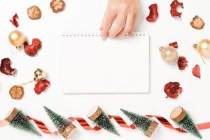 Minimal creative flat lay of winter christmas traditional composition and new year holiday season. Top view open mockup black notebook for text on white background. Mock up and copy space photography. photo