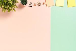 Minimal work space - Creative flat lay photo of workspace desk. Top view office desk with adhesive note on pastel green pink color background. Top view with copy space, flat lay photography.