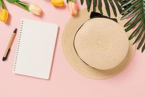 Creative flat lay of travel vacation spring or summer tropical fashion. Top view beach accessories open mockup black notebook for text on pastel background. Top view mock up copy space photography. photo