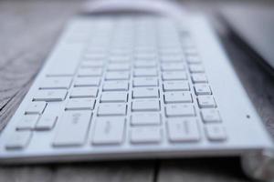 close up keyboard on wooden table and business concept photo