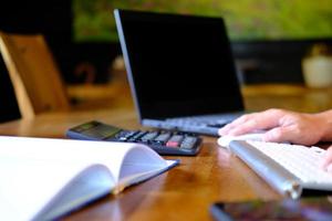 Man hand working on laptop computer on table and home quarantine, new normal photo
