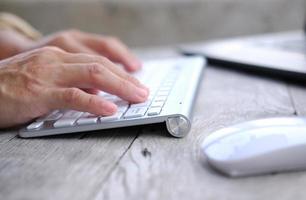 close up keyboard on wooden table and business concept photo