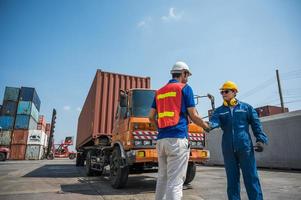 El capataz y el personal de los trabajadores portuarios se dan la mano para trabajar con éxito en el puerto de carga de contenedores. concepto de envío de exportación de importación de logística empresarial. foto