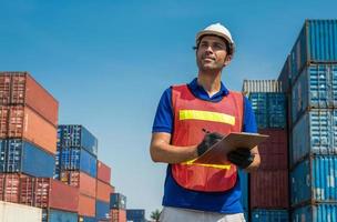 Foreman holding clipboard working at Container cargo harbor. Business Logistics import export shipping concept. photo