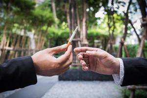Two businessman sharing a cigarette photo