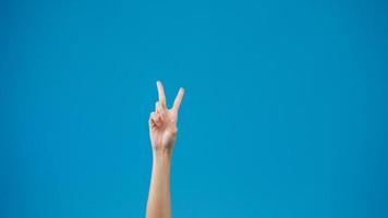 Young woman hand showing thumb up sign with fingers isolated over blue background in studio. Copy space for place a text, message for advertisement. Advertising area, mock up promotional content.