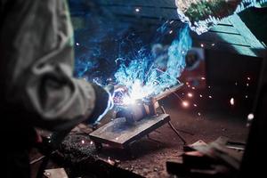 Industrial factory weld worker. Welding or welder master weld the steel photo
