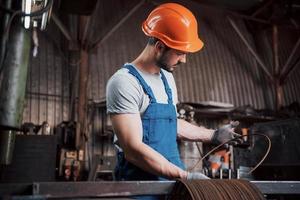 Experienced operator in a hard hat. Metalworking industry concept professional engineer metalworker operating CNC milling machine center in manufacturing workshop photo