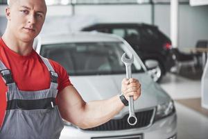 Hands of car mechanic with wrench in garage photo