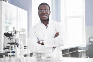 The scientist works with a microscope in a laboratory conducting experiments and formulas. photo