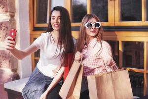 Two women talking after shopping on the street near the window photo