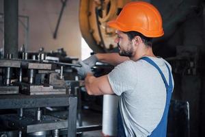 Experienced operator in a hard hat. Metalworking industry concept professional engineer metalworker operating CNC milling machine center in manufacturing workshop photo
