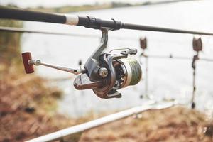 Carp fishing rods standing on special tripods. Expensive coils and a radio system of crochet photo