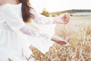 hermosa chica en un campo de trigo con un vestido blanco, una imagen perfecta en el estilo de vida foto