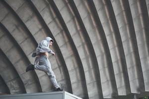 The man outdoors practices parkour, extreme acrobatics. photo