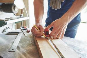 A man works in a joiner's shop, working with a tree. photo