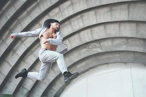 Man engaged in parkour jumping on the street workout. photo