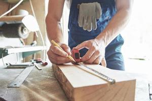 A man works in a joiner's shop, working with a tree. photo