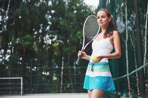Portrait of a beautiful woman practicing tennis. photo