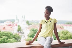 Joven y bella mujer de negocios afroamericana tomando café en un café foto