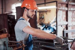 Experienced operator in a hard hat. Metalworking industry concept professional engineer metalworker operating CNC milling machine center in manufacturing workshop photo