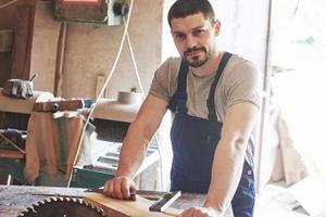 A man works in a joiner's shop, working with a tree. photo