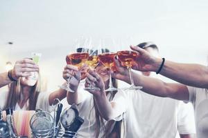 concepto de ocio y comunicación. Grupo de amigos sonrientes felices disfrutando de bebidas y hablando en el bar o pub foto