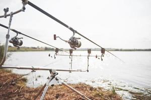 cañas de pescar carpas de pie sobre trípodes especiales. bobinas caras y un sistema de radio de crochet foto