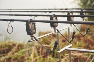 Carp fishing rods standing on special tripods. Expensive coils and a radio system of crochet photo