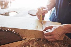 A man works in a joiner's shop, working with a tree. photo