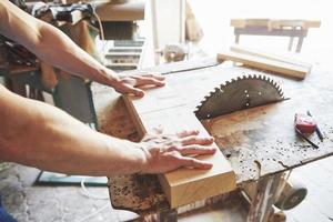 A man works in a joiner's shop, working with a tree. photo