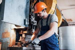 Experienced operator in a hard hat. Metalworking industry concept professional engineer metalworker operating CNC milling machine center in manufacturing workshop photo