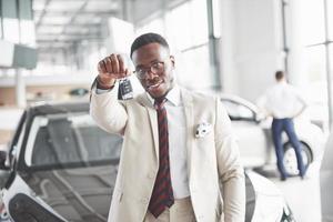 The young attractive black businessman buys a new car, dreams come true photo