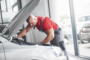 Picture showing muscular car service worker repairing vehicle photo