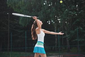 retrato de una bella mujer practicando tenis. foto