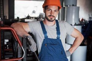 Experienced operator in a hard hat. Metalworking industry concept professional engineer metalworker operating CNC milling machine center in manufacturing workshop photo