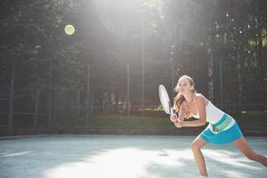 Cute girl playing tennis and posing for the camera. photo