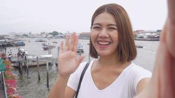 glimlach mooie aziatische vrouw die selfies neemt op een smartphone. video