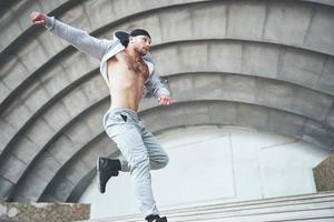 un joven está saltando. parkour en espacio urbano, actividad deportiva. foto