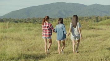 mujeres asiáticas tomados de la mano caminando divirtiéndose juntos un viaje de verano. video