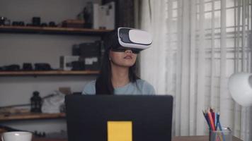 garota asiática feliz usando fone de ouvido de realidade virtual 3d em casa.