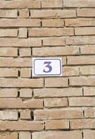 Number three on a brick wall photo