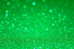 Green abstract glitter background with defocused lights photo