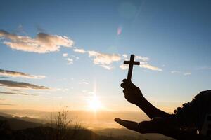 silueta, de, asimiento de la mano, cruz de dios foto